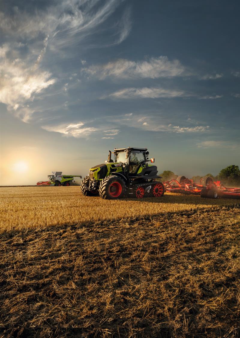 Claas Traktur bei der Feldarbeit bei untergehender Sonne 