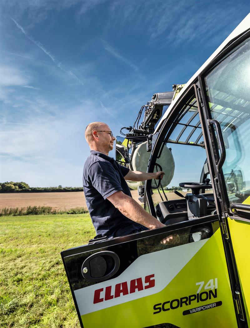 Mann der in einen Claas Traktur einsteigt 