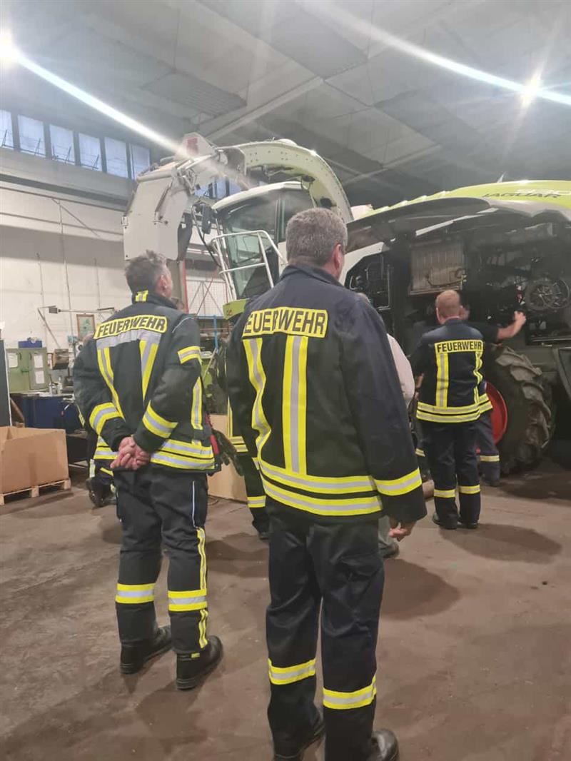 Feuerwehr bei der Inspektions unserer Landwirtschaftsfahrzeuge (Fahrzeuge in der Halle)
