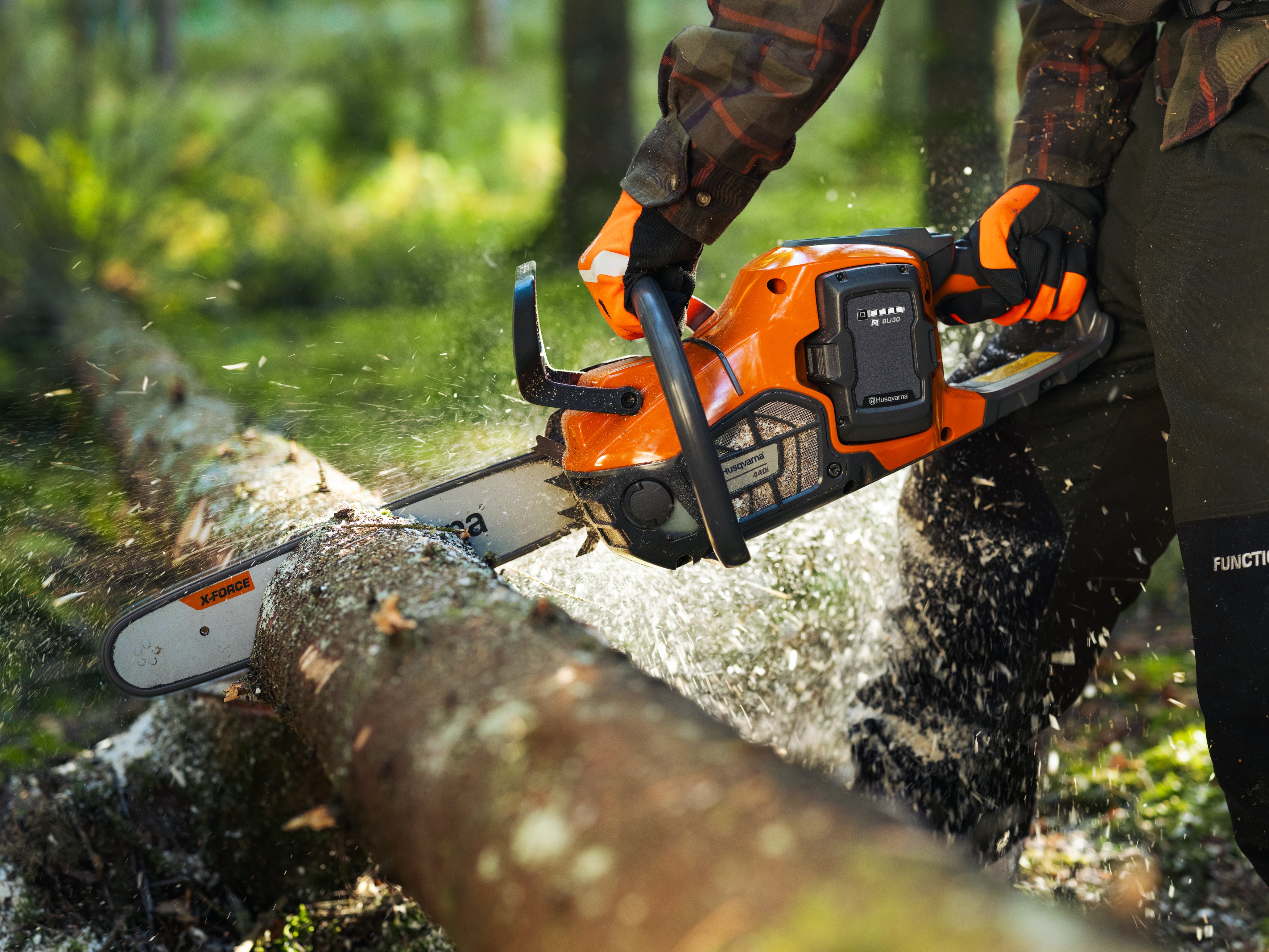 Mann der mit einer Husqvarna Motorsäge einen Baum schneidet (Nahaufnahme der Motorsäge)