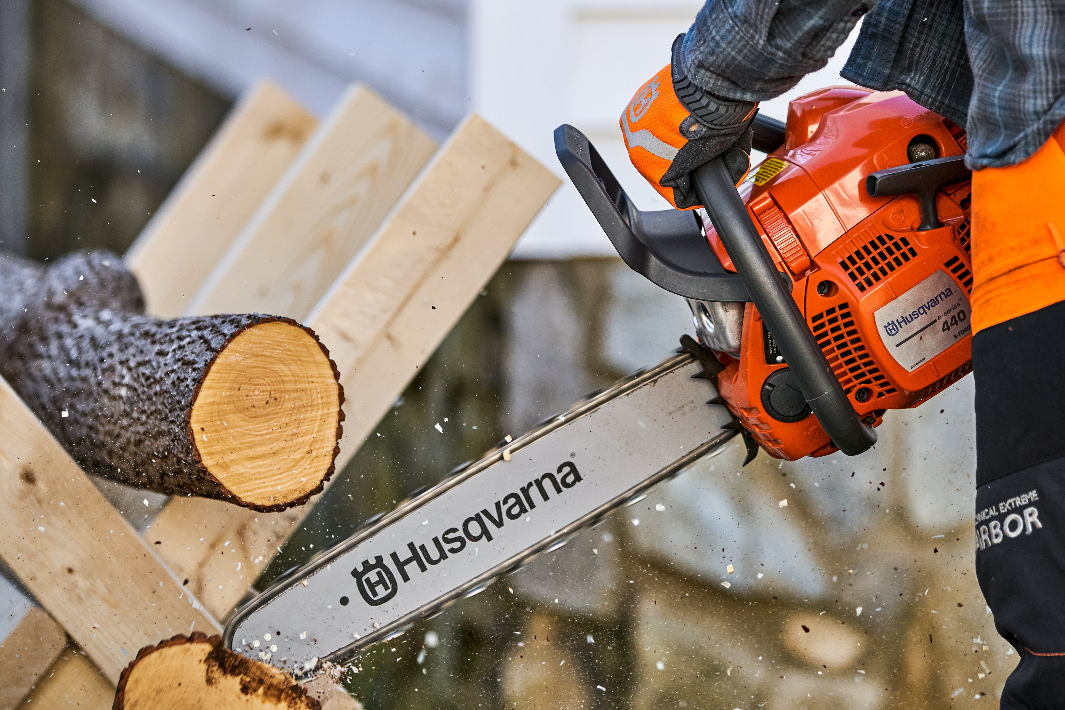 Mann der mit einer Husqvarna Motorsäge einen Baum schneidet (Nahaufnahme der Motorsäge)