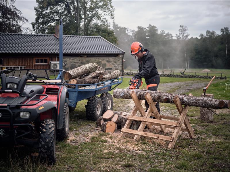 Mann der mit einer Husqvarna Motorsäge einen Baum schneidet