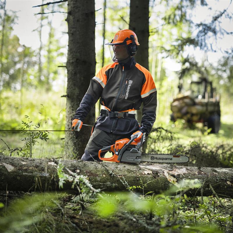 Mann der mit einer Husqvarna Motorsäge im Wald